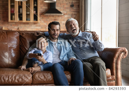 Three male members of multi generational family watching tv together 84293393
