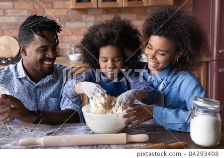 Happy African American family preparing pastry at home. Happy African American family preparing pastry at home. 84293408