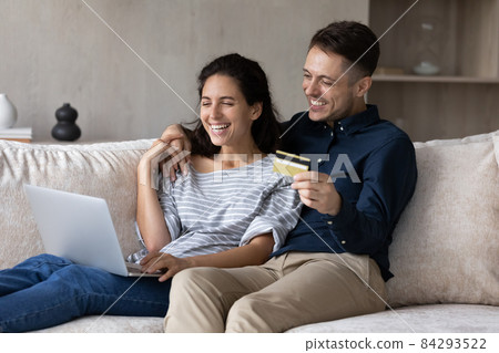 Couple use laptop hold credit card buying on internet Couple use laptop hold credit card buying on internet 84293522