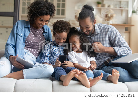Happy family couple, little son and daughter using digital gadgets Happy family couple, little son and daughter using digital gadgets 84293851