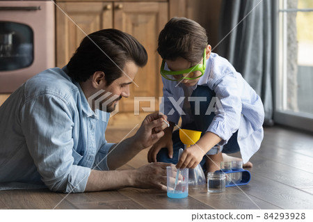 Caring millennial father and preteen son doing funny chemical experiments Caring millennial father and preteen son doing funny chemical experiments 84293928