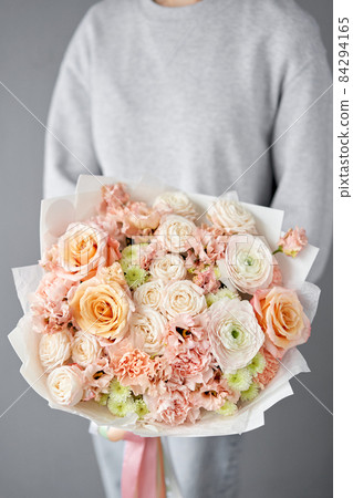 Flower arrangement in Wicker basket. Beautiful bouquet of mixed flowers in woman hand. Handsome fresh bouquet. Small flower shop and Flowers delivery. Flower arrangement in Wicker basket. Beautiful bouquet of mixed flowers in woman hand. Handsome fresh bouquet. Small flower shop and Flowers delivery. 84294165