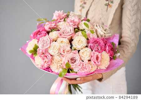 Beautiful bouquet of mixed flowers in woman hand. Floral shop concept . Beautiful fresh cut bouquet. Flowers delivery 84294189