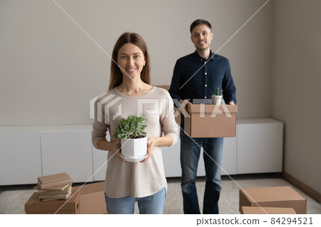 Portrait happy couple enjoying moving day, holding cardboard box Portrait happy couple enjoying moving day, holding cardboard box 84294521