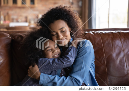 Happy loving African American little girl cuddling mom. Happy loving African American little girl cuddling mom. 84294523