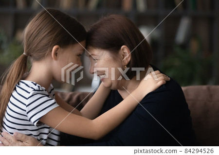 Close up happy mature grandmother and granddaughter touching foreheads 84294526