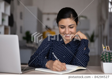 Happy young Indian woman studying on online courses. Happy young Indian woman studying on online courses. 84294527