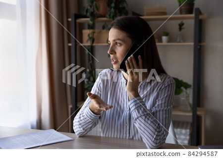 Focused young woman involved in mobile phone call talk. 84294587