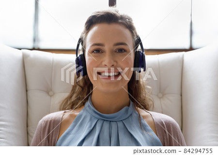 Happy young woman in headphones holding video call meeting. 84294755