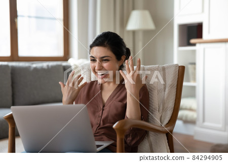 Indian woman read news on laptop feels euphoric celebrate success 84294905
