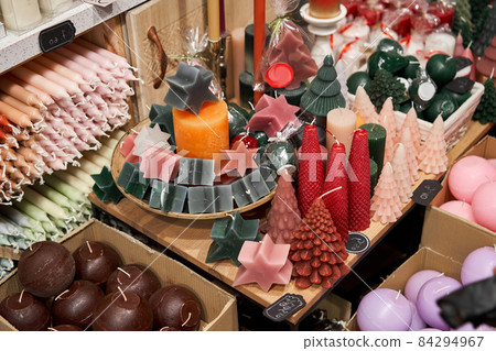 Candles for sale in interior decorating store. Variety coloured aroma candles in large candle shop. Discounts on price tags, sale. 84294967