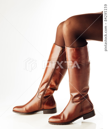 woman legs wearing brown leather high boots 84295159