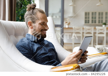 Happy young hipster man using digital touchpad gadget. 84295226
