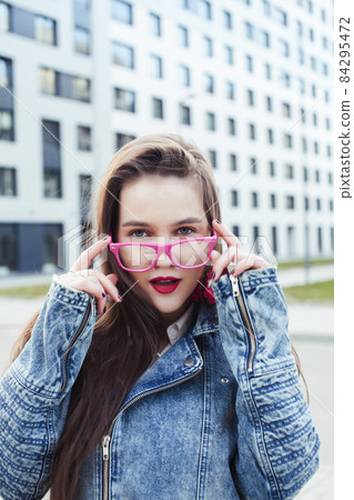 young pretty brunette business woman posing emotional against modern building in glasses holding coffee, lifestyle people concept 84295472