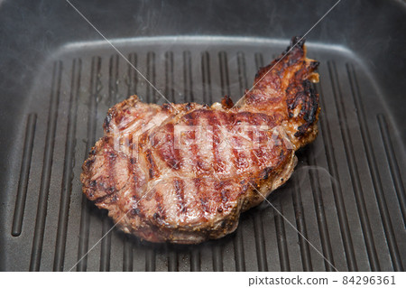 frying beef steak on a ribbed grill pan 84296361