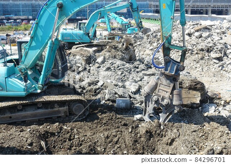 Building demolition work site with large heavy machinery demolished 84296701