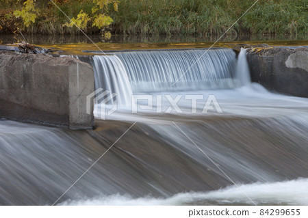 old river dam with falling water 84299655
