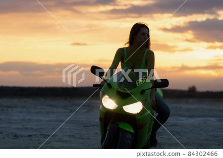 Cool woman in helmet on motorbike on beach Cool woman in helmet on motorbike on beach 84302466
