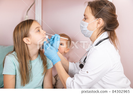 Pediatrician taking nasal test sample from child at home during lockdown 84302965