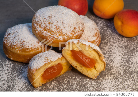 Freshly cooked Apricot jam doughnuts, referred to as jelly doughnuts, donuts in the US 84303775