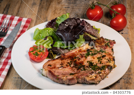Recipe for grilled pork chop, maple syrup and fresh cilantro marinade, parsley, garlic, served with 84303776