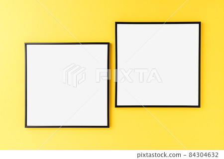 Two empty picture frames on yellow wall. Mockup with copyspace Two empty picture frames on yellow wall. Mockup with copyspace 84304632