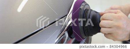 Hands with orbital polisher in car workshop polishing headlight of car Hands with orbital polisher in car workshop polishing headlight of car 84304966