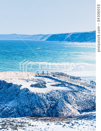 Winter wonderland and Christmas fantasy landscape. Frozen sea coast and mountains covered with snow as holiday background Winter wonderland and Christmas fantasy landscape. Frozen sea coast and mountains covered with snow as holiday background 84306058