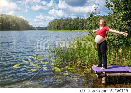 Pregnant woman enjoying nature in a summer forest Pregnant woman enjoying nature in a summer forest 84306199