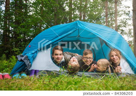 Children in a camping tent enjoying summer holidays Children in a camping tent enjoying summer holidays 84306203