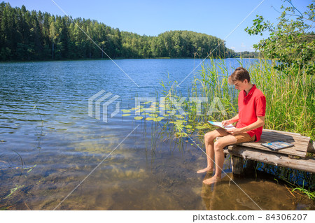 Teen boy sketching summer landscape with pastel sticks 84306207