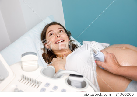 Joyful pregnant woman received good news doing obstetric ultrasonography 84306209