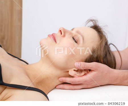 Woman receiving osteopathic treatment of her neck 84306219