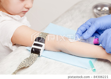 Nurse takes a blood sample from little girls arm - pediatric venipuncture  procedure 84306221