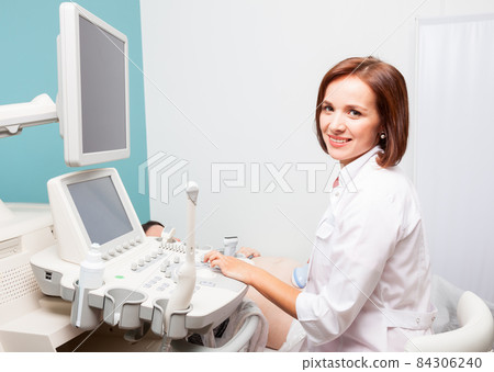 Doctor operating ultrasound machine performing obstetric ultrasonography 84306240