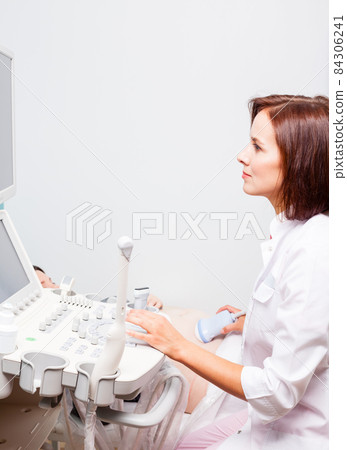 Doctor operating ultrasound machine performing obstetric ultrasonography 84306241