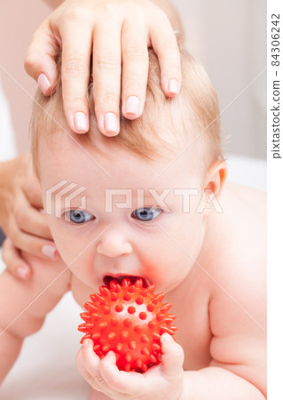 Little baby receiving osteopathic treatment of head and neck 84306242