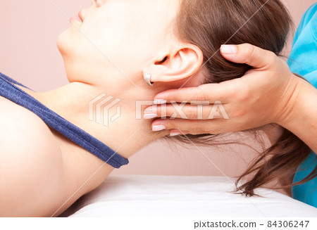 Woman receiving osteopathic treatment of her neck Woman receiving osteopathic treatment of her neck 84306247