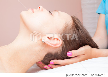 Woman receiving osteopathic treatment of her neck Woman receiving osteopathic treatment of her neck 84306248