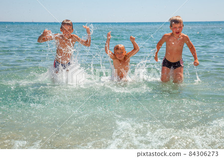Children playing on a beach 84306273