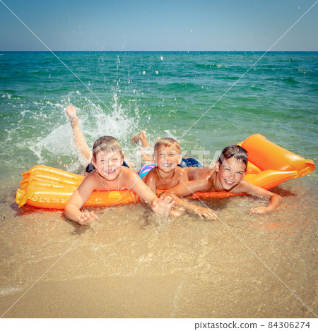Children playing on a beach 84306274