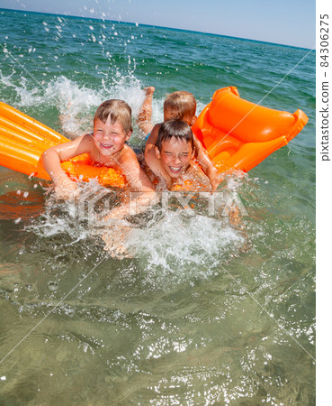 Children playing on a inflatable mattress 84306275