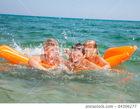 Children playing on a inflatable mattress Children playing on a inflatable mattress 84306277