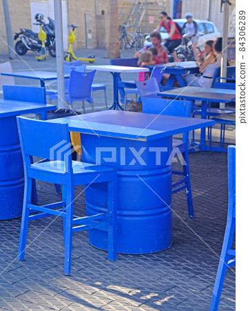 Street cafe in the port of Old Jaffa in Tel Aviv. The furniture is painted bright blue and tables are made from old fuel barrels. Street cafe in the port of Old Jaffa in Tel Aviv. The furniture is painted bright blue and tables are made from old fuel barrels. 84306289