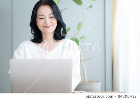 一個美麗的 Alafor 日本女人在電腦上工作,有一個向下的複制空間 一個美麗的 Alafor 日本女人在電腦上工作,有一個向下的複制空間 84306412