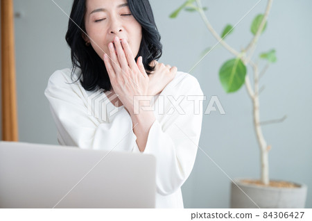 Beautiful Alafor Asian (Japanese female) with copy space yawning during work breaks Close-up 84306427