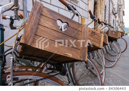 Rental city bicycles with wooden baskets in Pietrasanta, Italy Rental city bicycles with wooden baskets in Pietrasanta, Italy 84306443