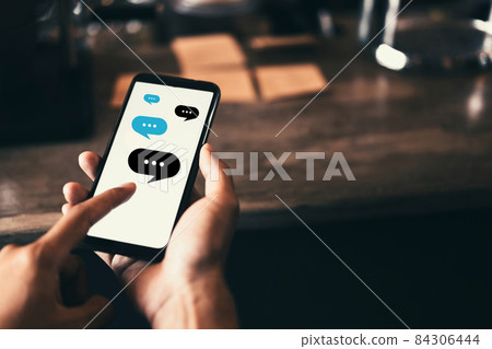 Woman hand using smart phone with chat icon graphic at coffee shop abstract background. Technology business and freelance concept. Woman hand using smart phone with chat icon graphic at coffee shop abstract background. Technology business and freelance concept. 84306444