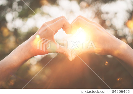 Female hands heart shape on nature bokeh sun light flare and blur leaf abstract background. Female hands heart shape on nature bokeh sun light flare and blur leaf abstract background. 84306465