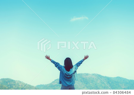 Copy space of woman rise hand up on top of mountain and sunset sky abstract background. Copy space of woman rise hand up on top of mountain and sunset sky abstract background. 84306484